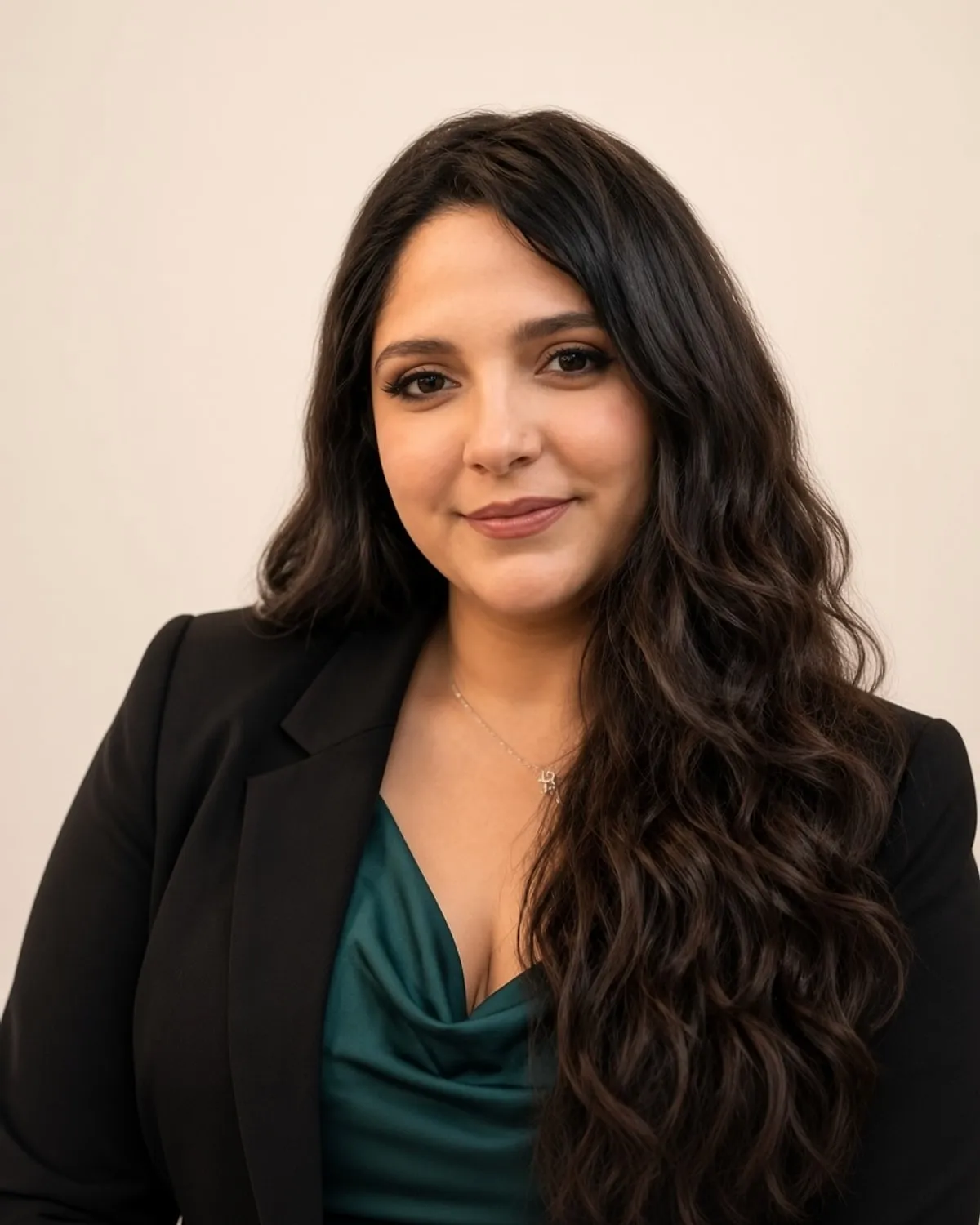 Ashley Art in a professional headshot, wearing a black blazer over an emerald top.