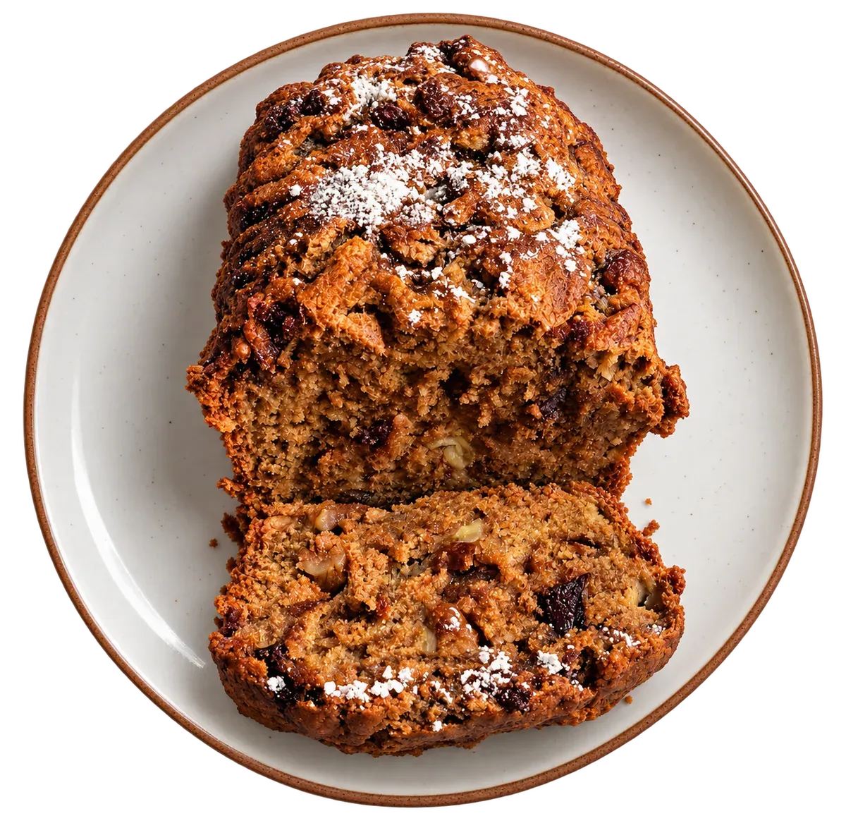 A powdered sugar walnut loaf on a plate, with one thick slice in front.